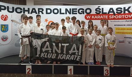 Karatecy z Klubu Antai na tle banera "Puchar Dolnego Śląska w Karate Sportowym - Silesia Cup 2022"