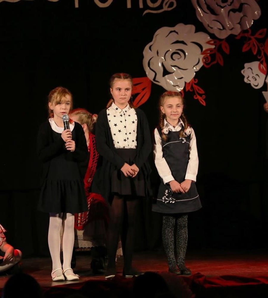 trzy recytujące dziewczynki stojące na scenie