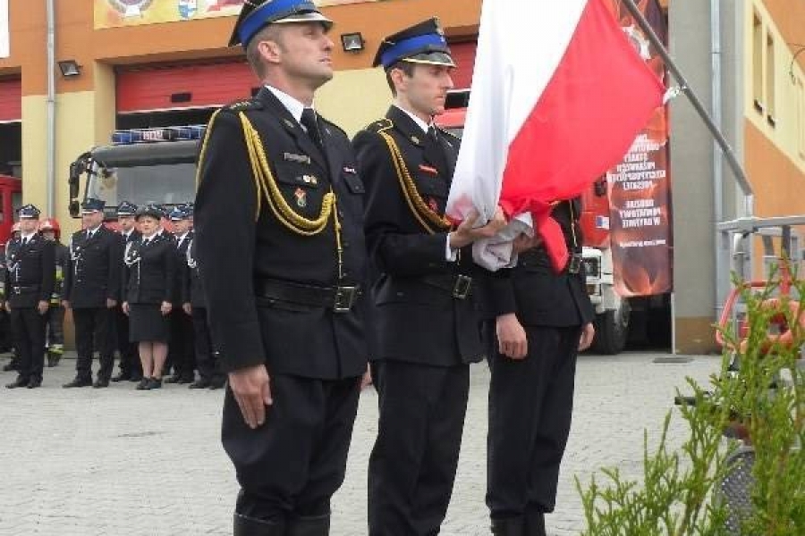 Troje strażaków trzyma flagę Polski 