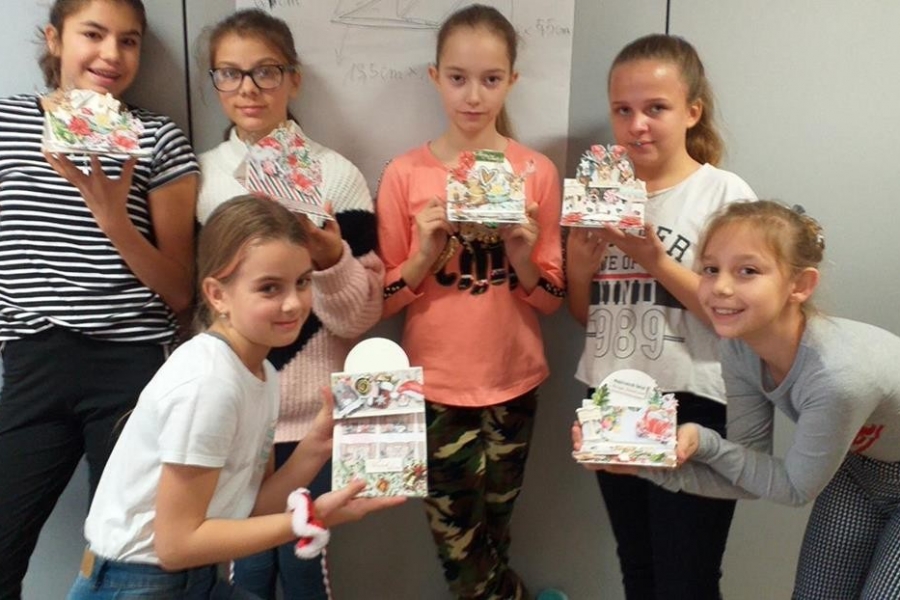 grupa dziewczynek prezentuje kompozycje papierowe wcześniej wycinane i sklejane    