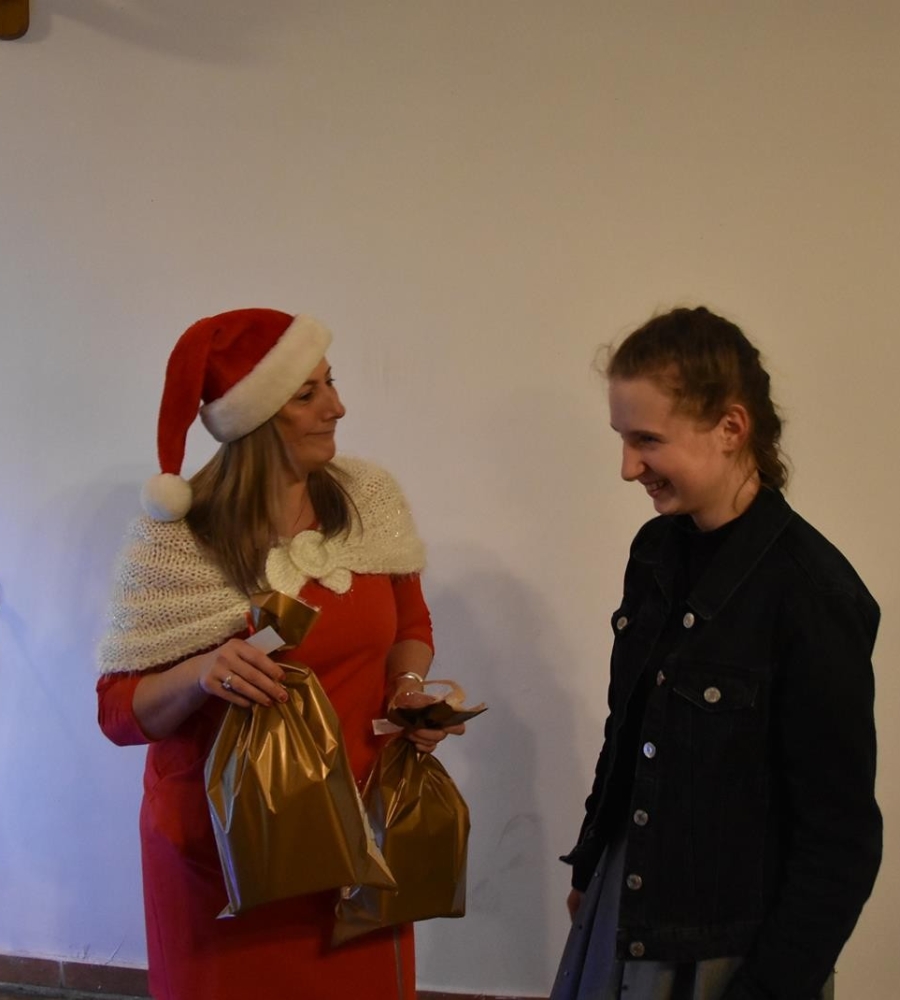 pani Mikołajowa trzyma paczki w rękach i rozmawia z dziewczyną