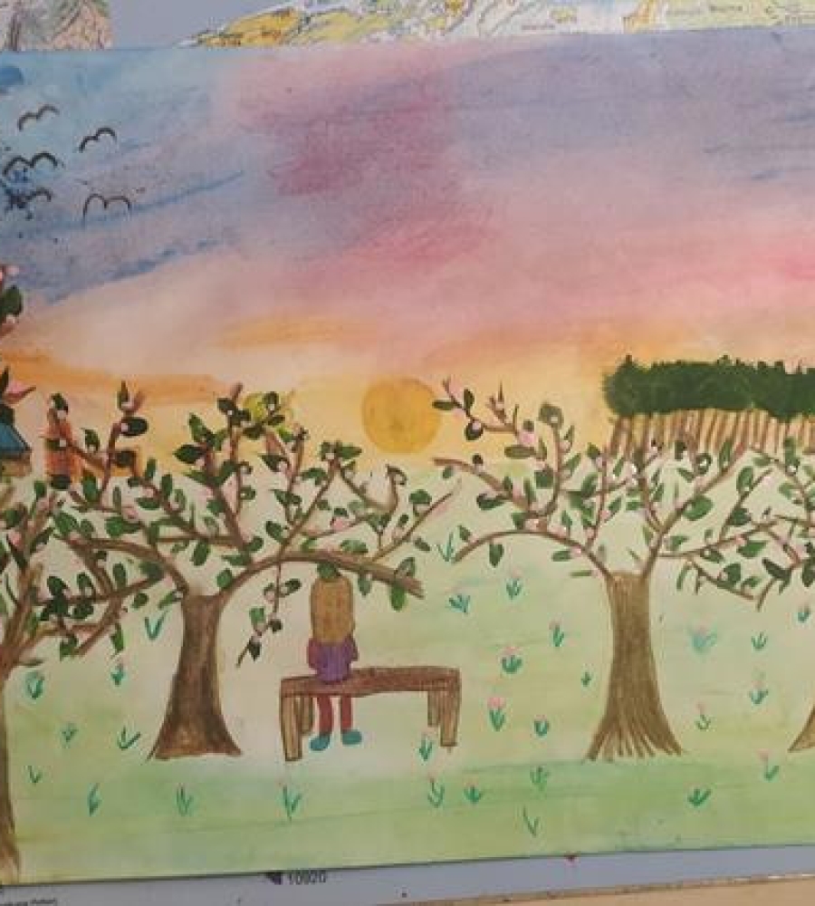 Siedząca dziewczynka na ławeczce wśród owocowych drzew