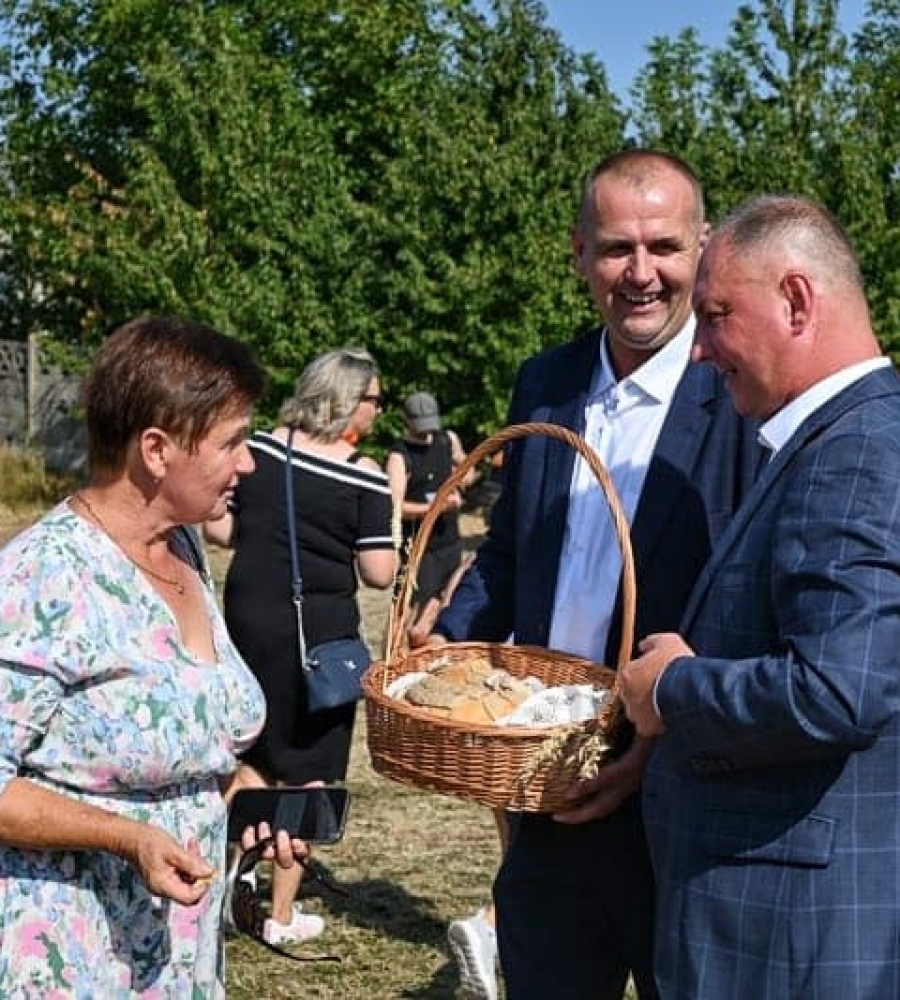 Wójt dzieli chlebem podczas uroczystości dożynkowej