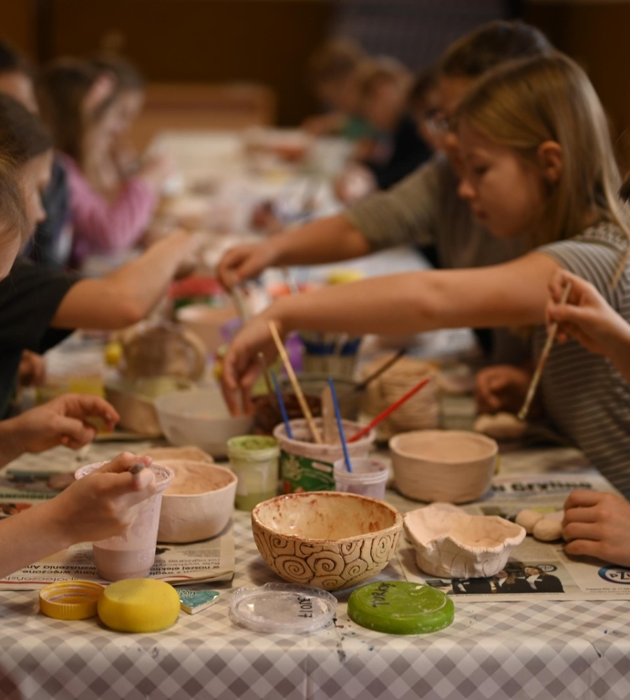 Dzieci podaczas szkliwienia wyrobów ceramicznych