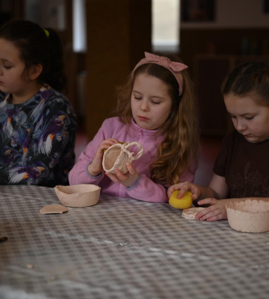 Trzy dziewczynki podczas szkliwienia wyrobów ceramicznych