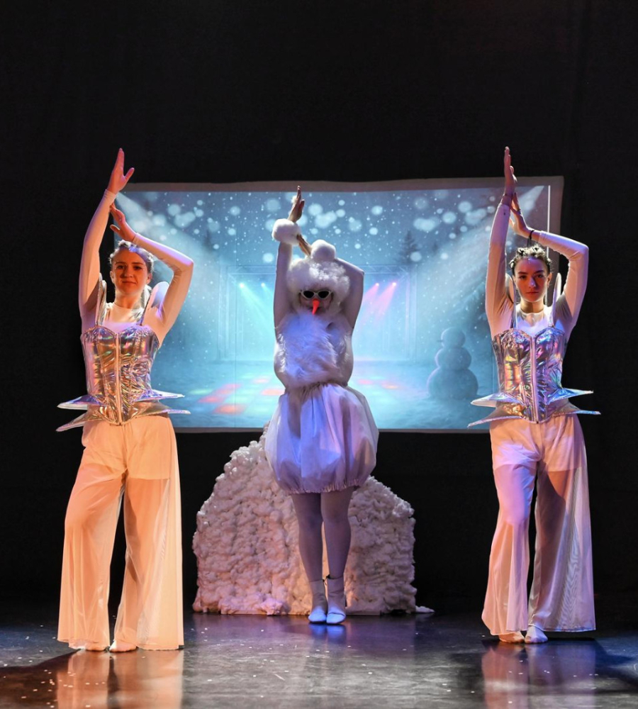 trzy osoby wykonują choreografię z białymi wachlarzami