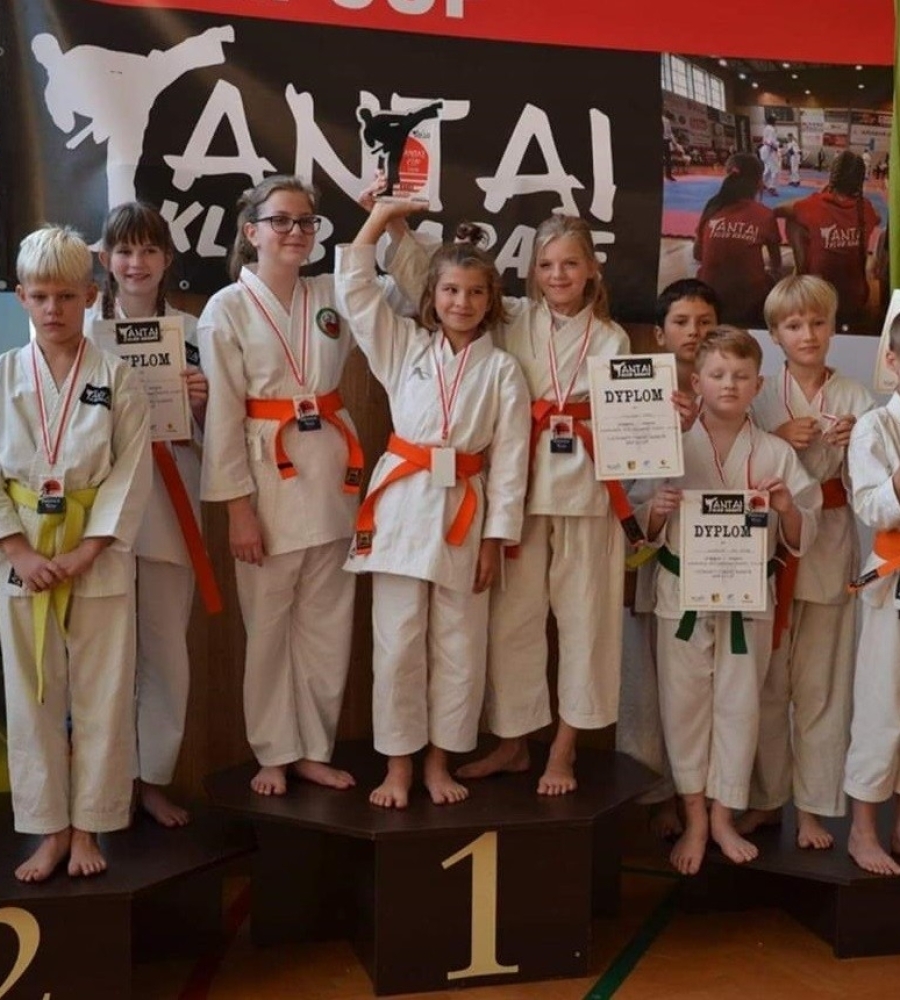 dziecięce drużyny karate stojące na podium