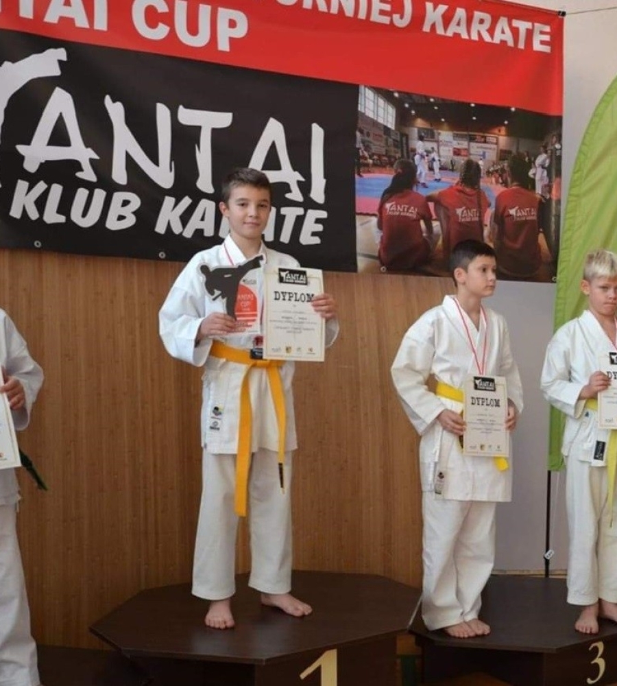 czterech stojących na podium uczestników turnieju karate