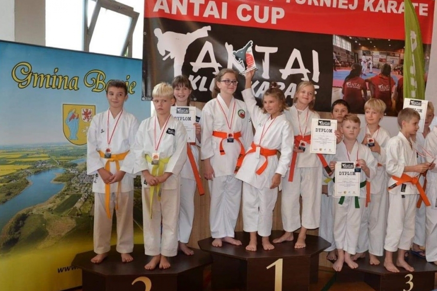 dziecięce drużyny karate stojące na podium